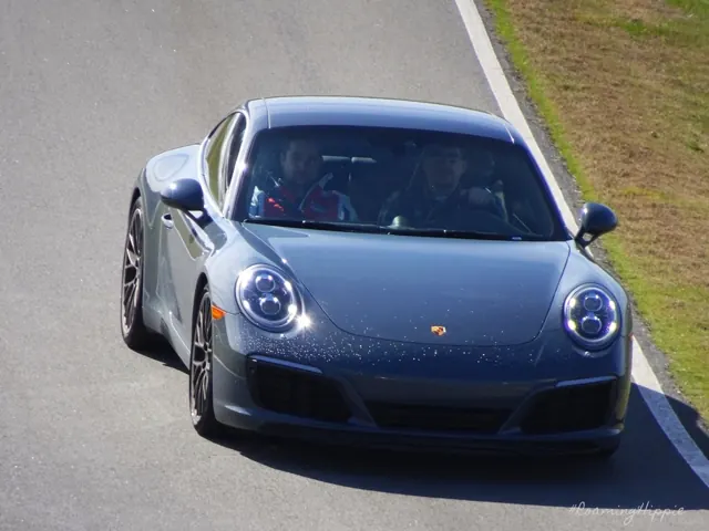 A grey Porsche 911 cornering on a race track