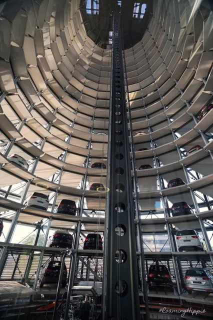 Looking up inside a glass car tower stacked with new cars