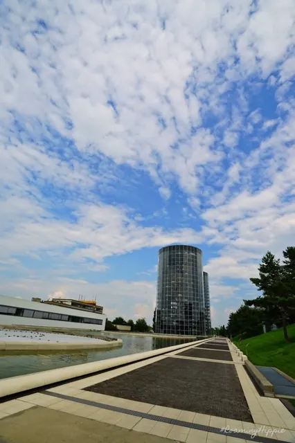 A modern glass tower at the end of a long reflecting pool