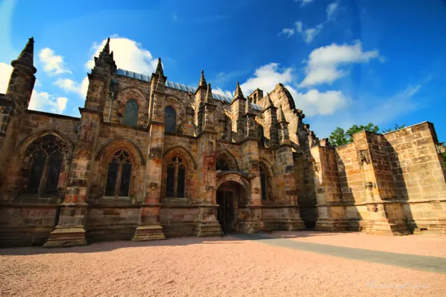 An ornately carved sandstone chapel under a blue sky