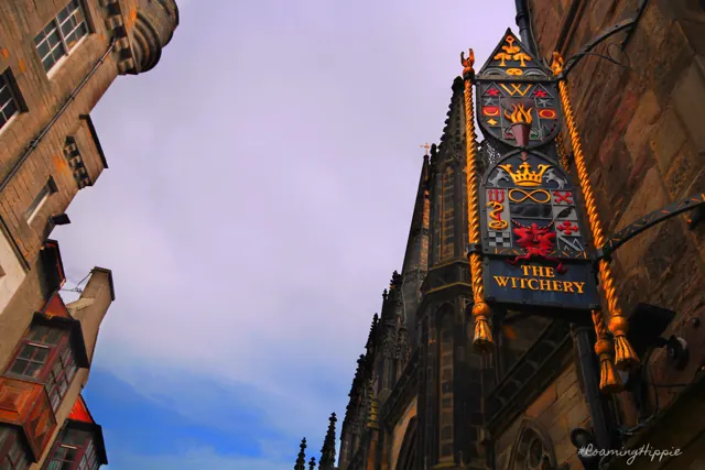The Witchery's painted sign hanging from an old stone building
