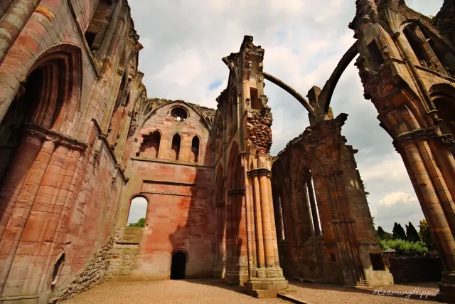 The soaring arches of a ruined red sandstone abbey