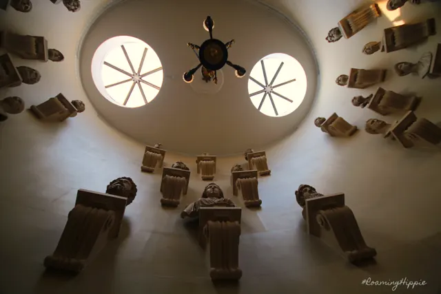 Looking up into a round domed room lined with carved figures